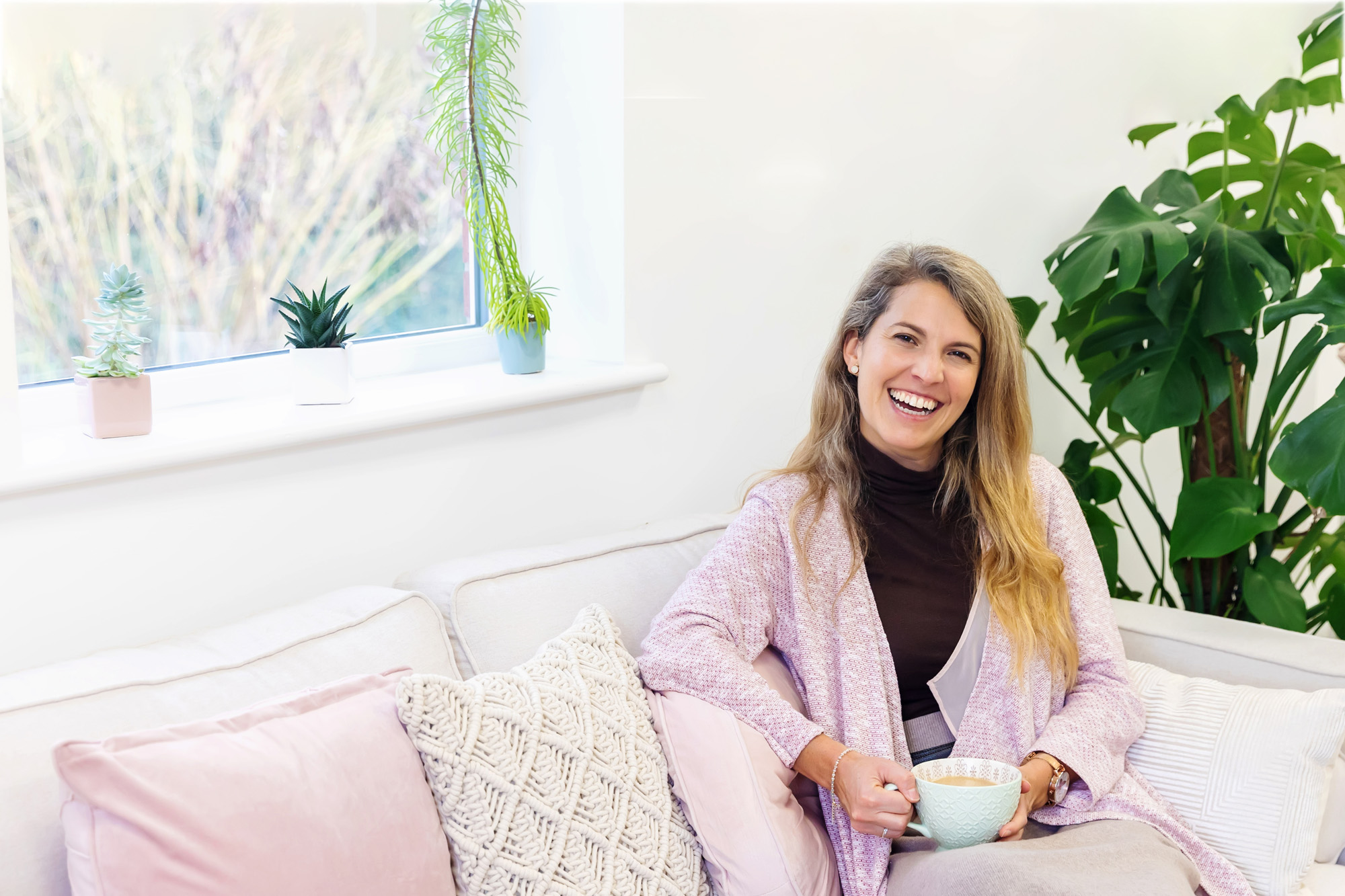 woman laughing on sofa captured for business website captured by Spotlight Lane in Nottingham