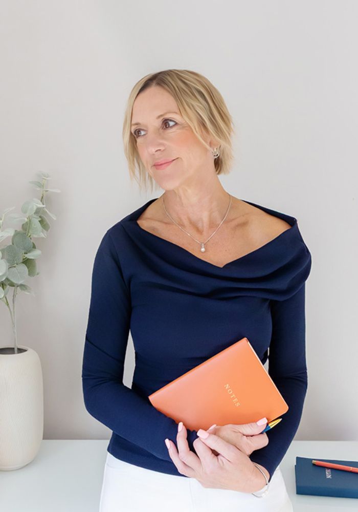 female SEO consultant at Spotlight Lane Alison Edwards holding notebook at desk